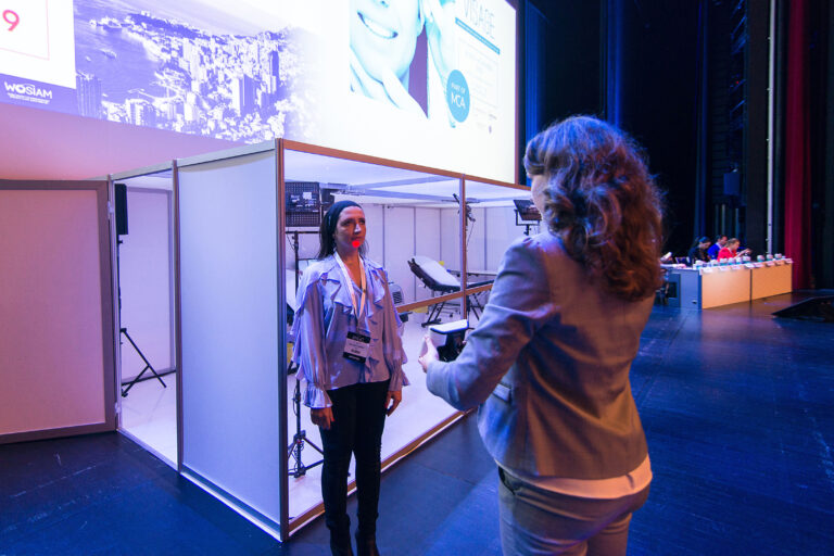 Photographe événementiel entreprise Monaco: Démonstration live d’un dispositif d’imagerie 3D sur la scène principale d’un salon professionnel.