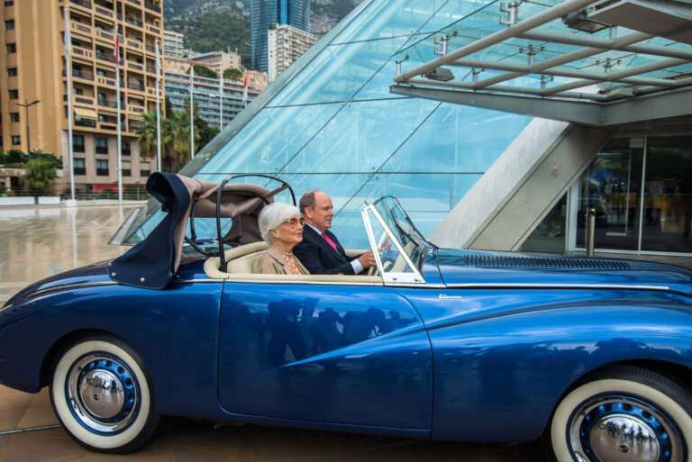 Photographe événementiel Côte d’Azur: Le Prince Albert II de Monaco au volant du véhicule rétrofité, accompagné de Brigitte Auber pour une démonstration.