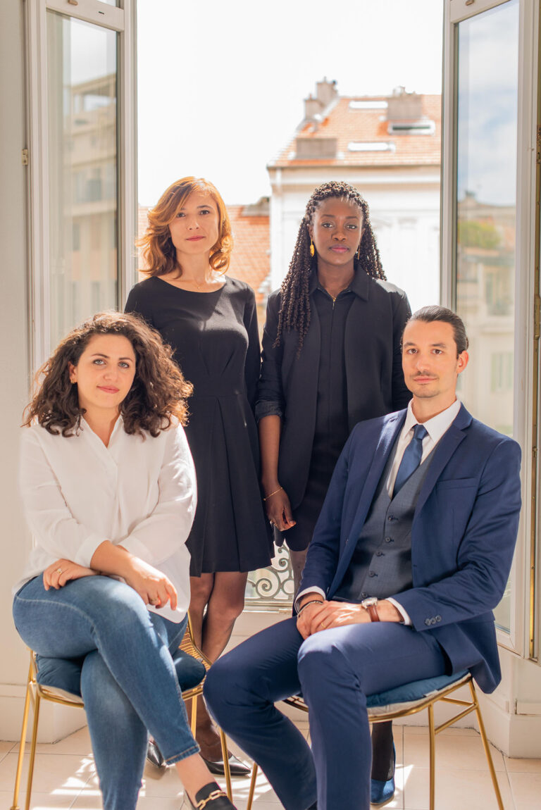 L’équipe d’un cabinet d’avocats réunie dans un cadre lumineux, symbole de confiance et d’expertise.