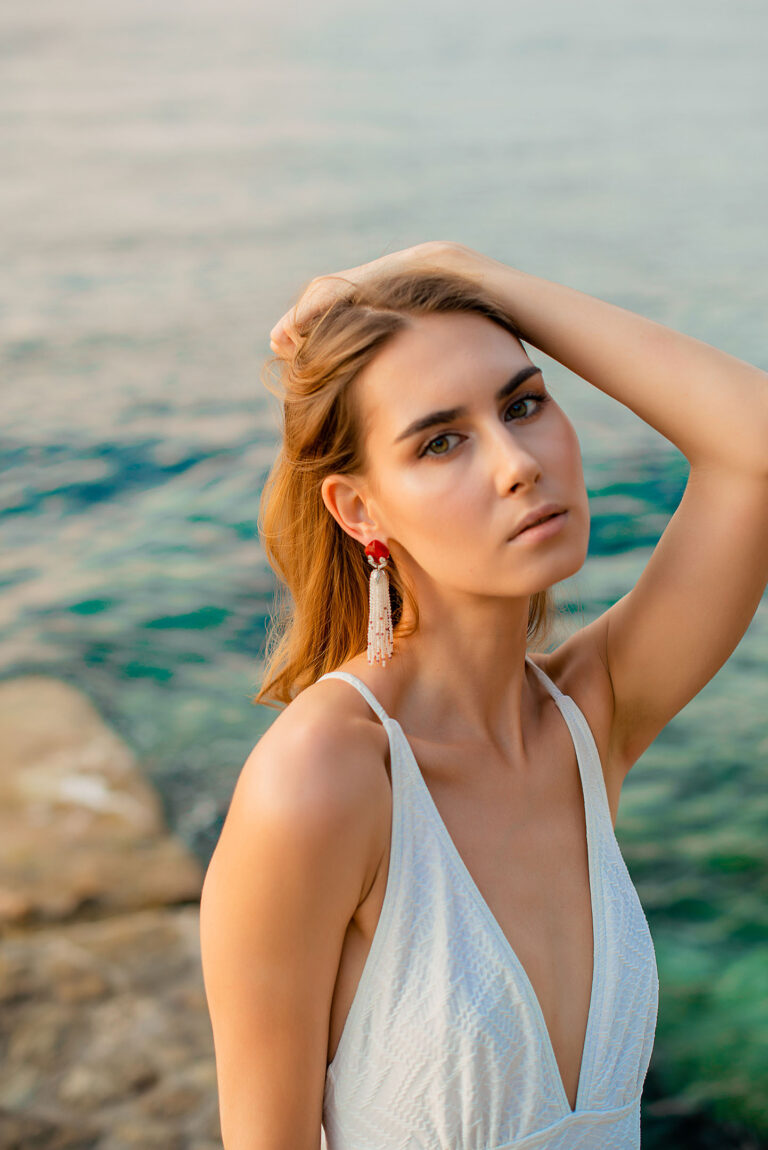 Féminité et délicatesse : boucles d’oreilles longues ornées de pierres et de perles en bord de mer.