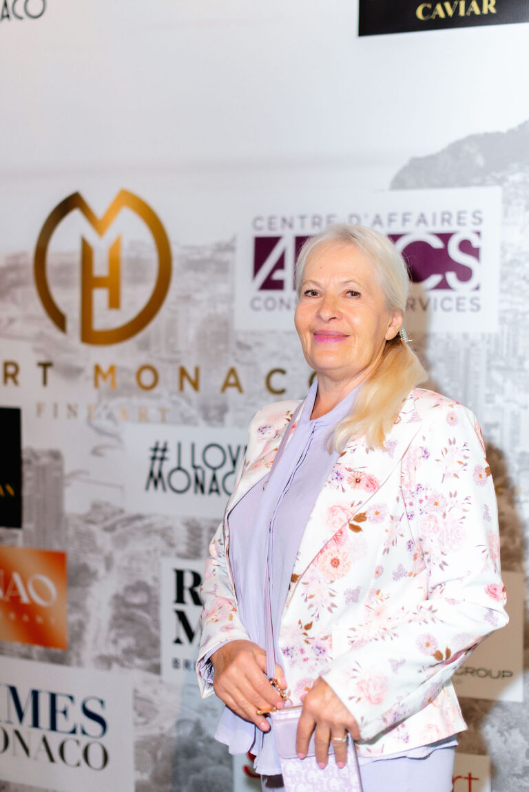 Portrait d’une invitée VIP posant devant le photocall de l’événement.