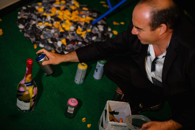 Performance artistique en direct : Faben dédicace une bouteille de champagne.