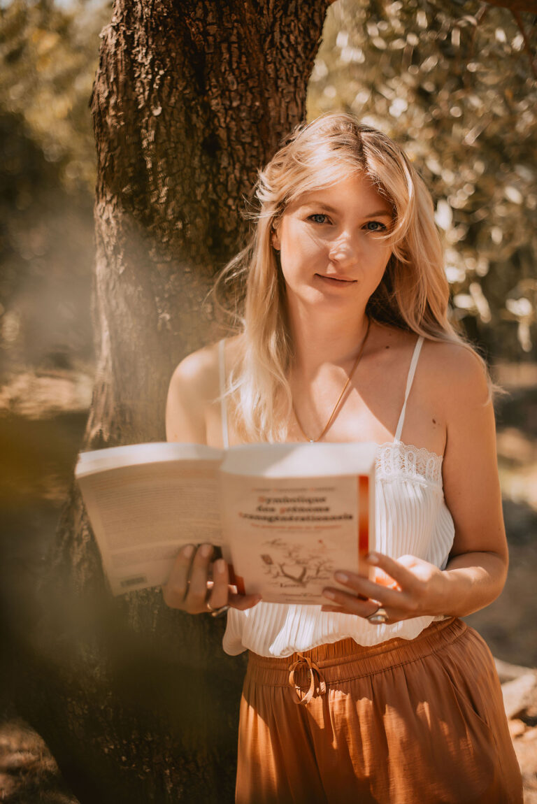 Portrait d’une entrepreneure du bien-être lisant un livre, symbole de sagesse et de transmission.