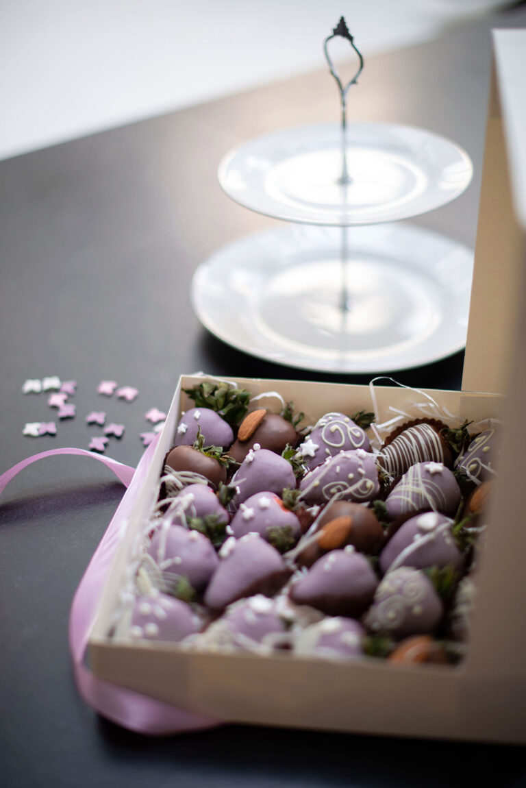 Photographie culinaire mettant en valeur des fraises artisanales décorées à la main.