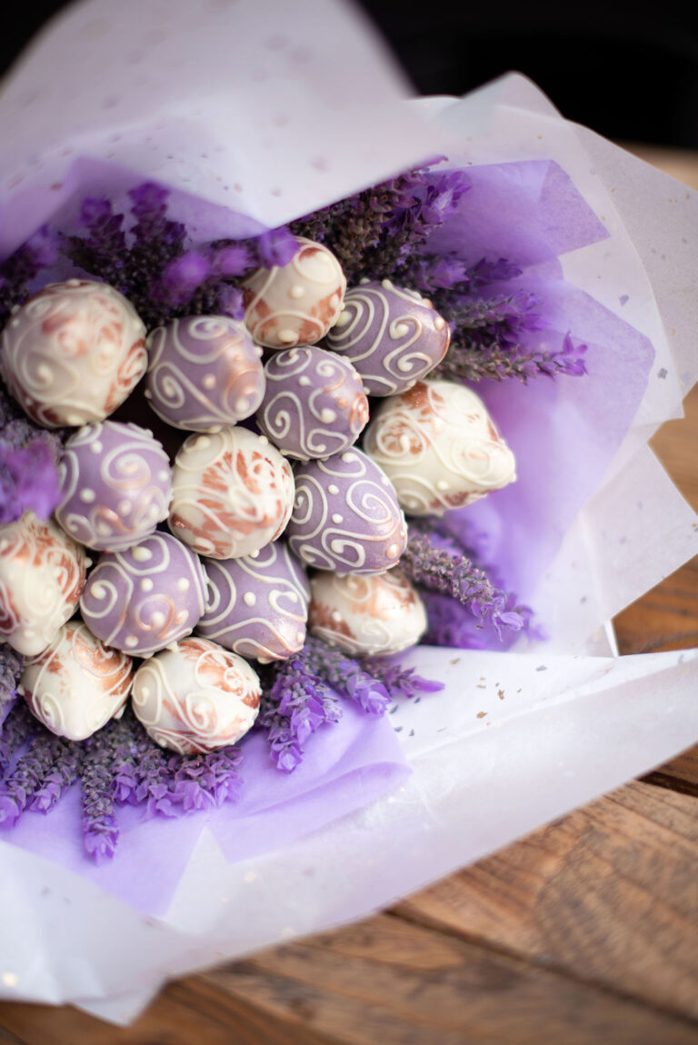 Gros plan sur des fraises enrobées de chocolat présentées sous forme d'un bouquet.