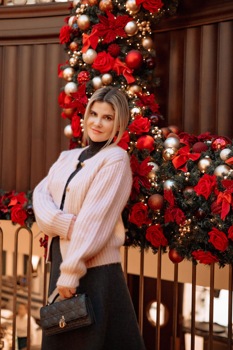 Photo chaleureuse d’une entrepreneure posant devant les décoration de Noël.