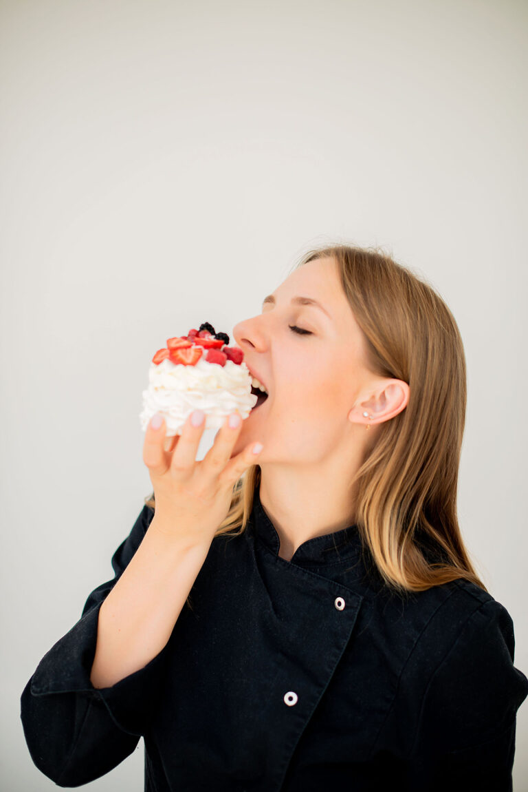 Portrait professionnel d’une pâtissière goûtant son propre dessert.