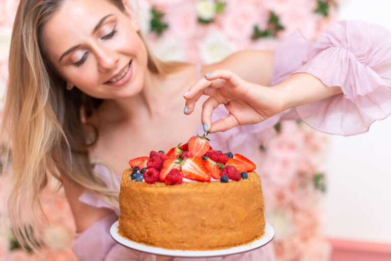 Portrait professionnel d’une pâtissière tenant son gâteau signature.