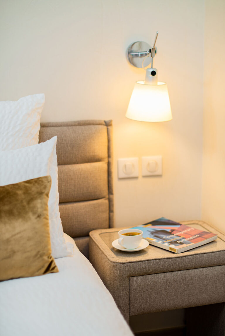 Table de chevet d’hôtel avec journal et café, instant détente.