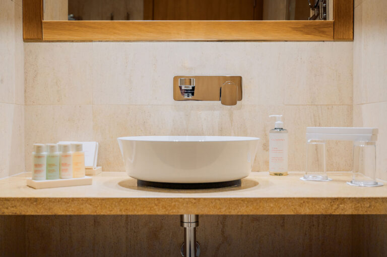 Salle de bain épurée et moderne – Lavabo en pierre naturelle, douche à l’italienne et touches de décoration méditerranéenne.