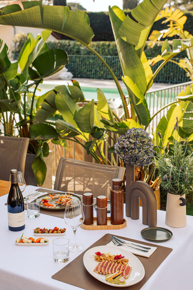 Table dressée en terrasse sous les oliviers – Ambiance conviviale et raffinée pour un repas en plein air au Cap d’Antibes.