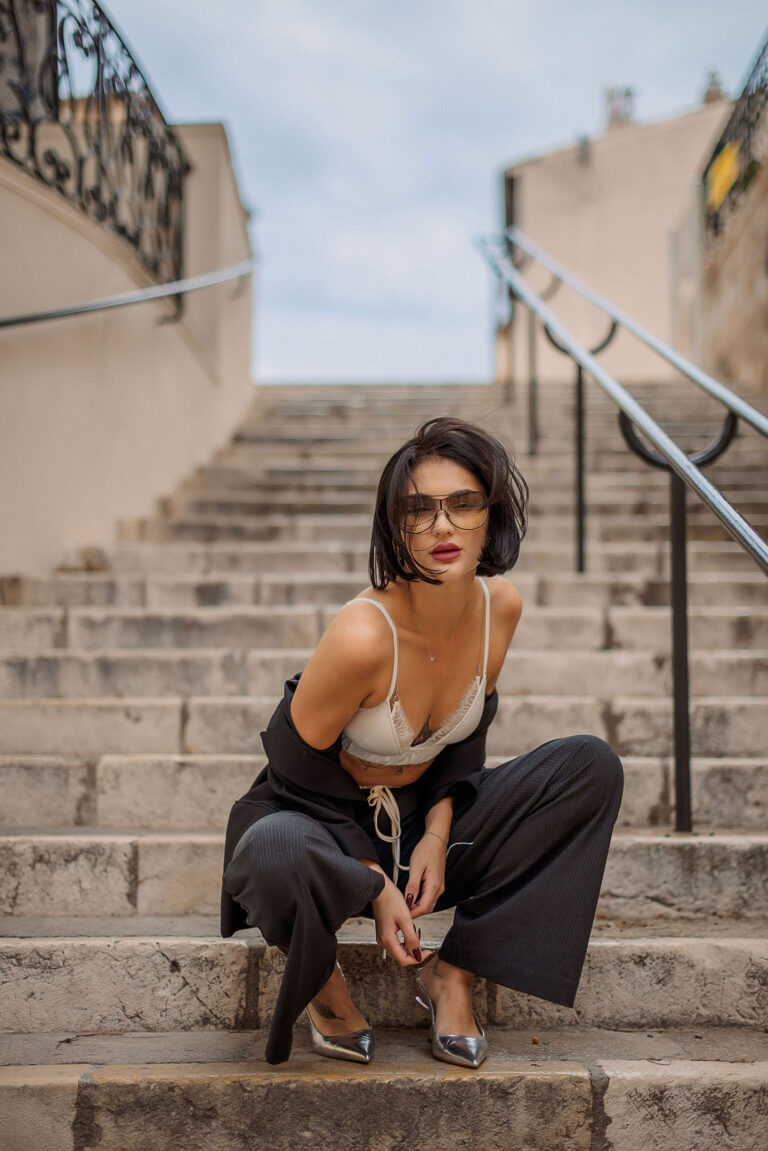 Portrait mode à Antibes : pose chic sur les marches en costume féminin élégant
