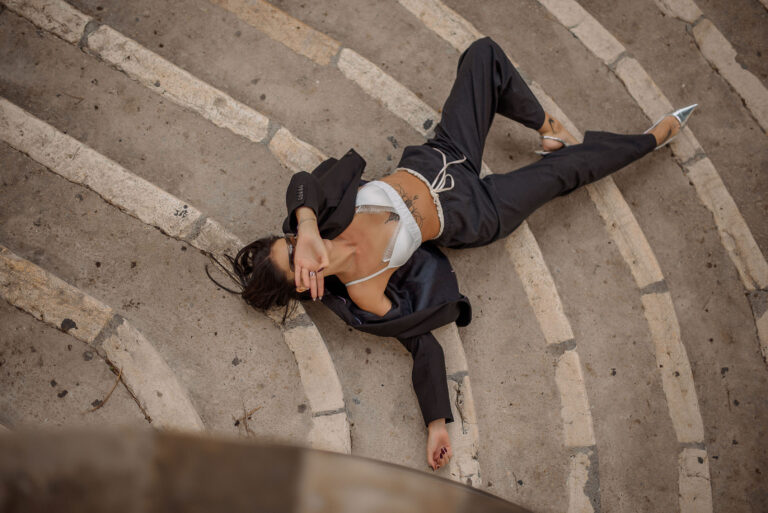 Séance photo lifestyle Côte d’Azur : modèle allongée sur des marches en tenue business chic