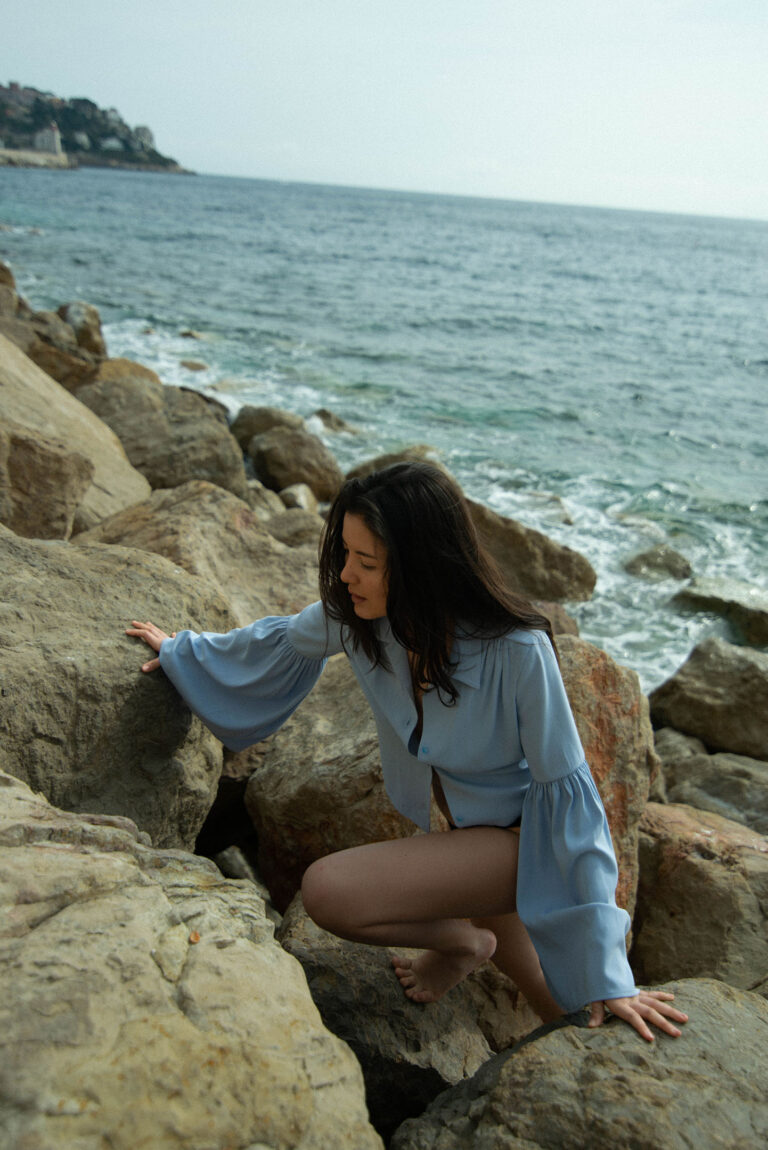 Portrait d’une femme au bord de la mer à Nice, ambiance rétro et cinématographique.