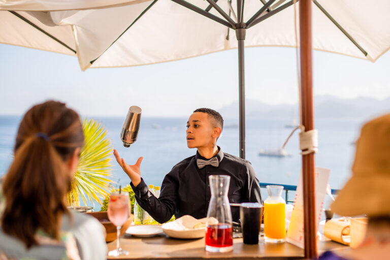 Un barman en pleine action, préparant un cocktail avec énergie et précision.