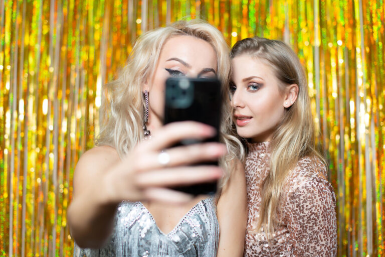 Photographe portrait entre amies à Nice : selfie complice et glamour de deux filles en pleine soirée festive.
