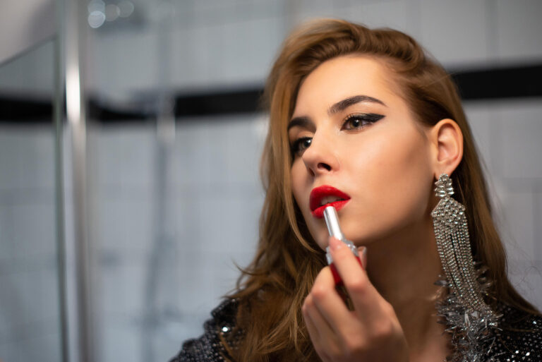 Coup de rouge à lèvres – Gros plan sur une amie appliquant son maquillage avant la séance photo.