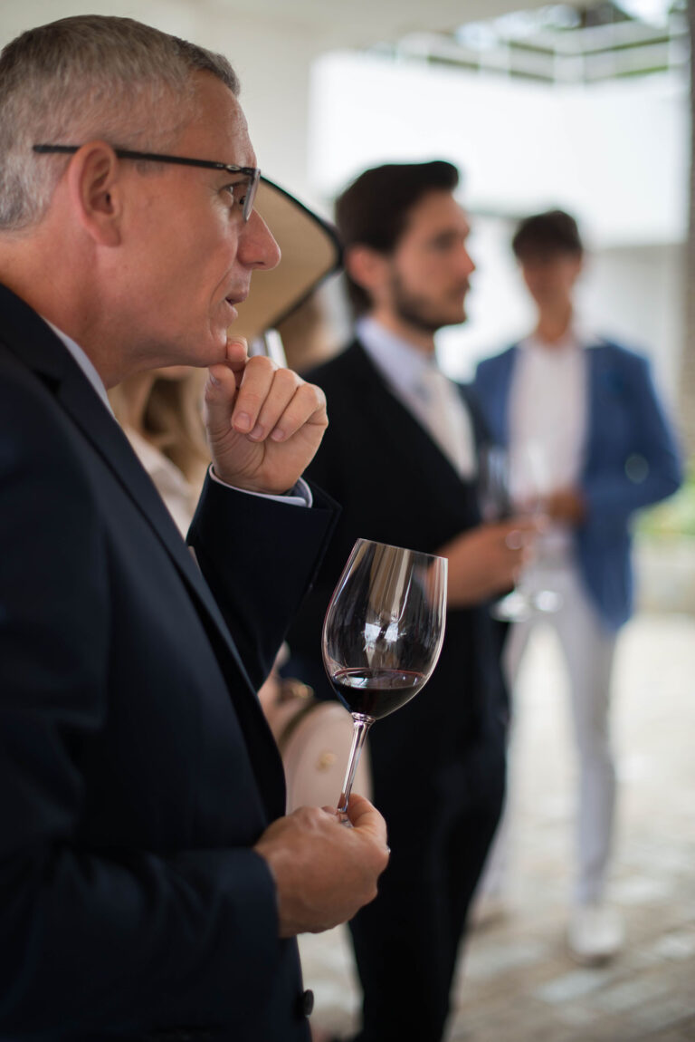 Un verre de vin à la main, un participant savoure l’instant.