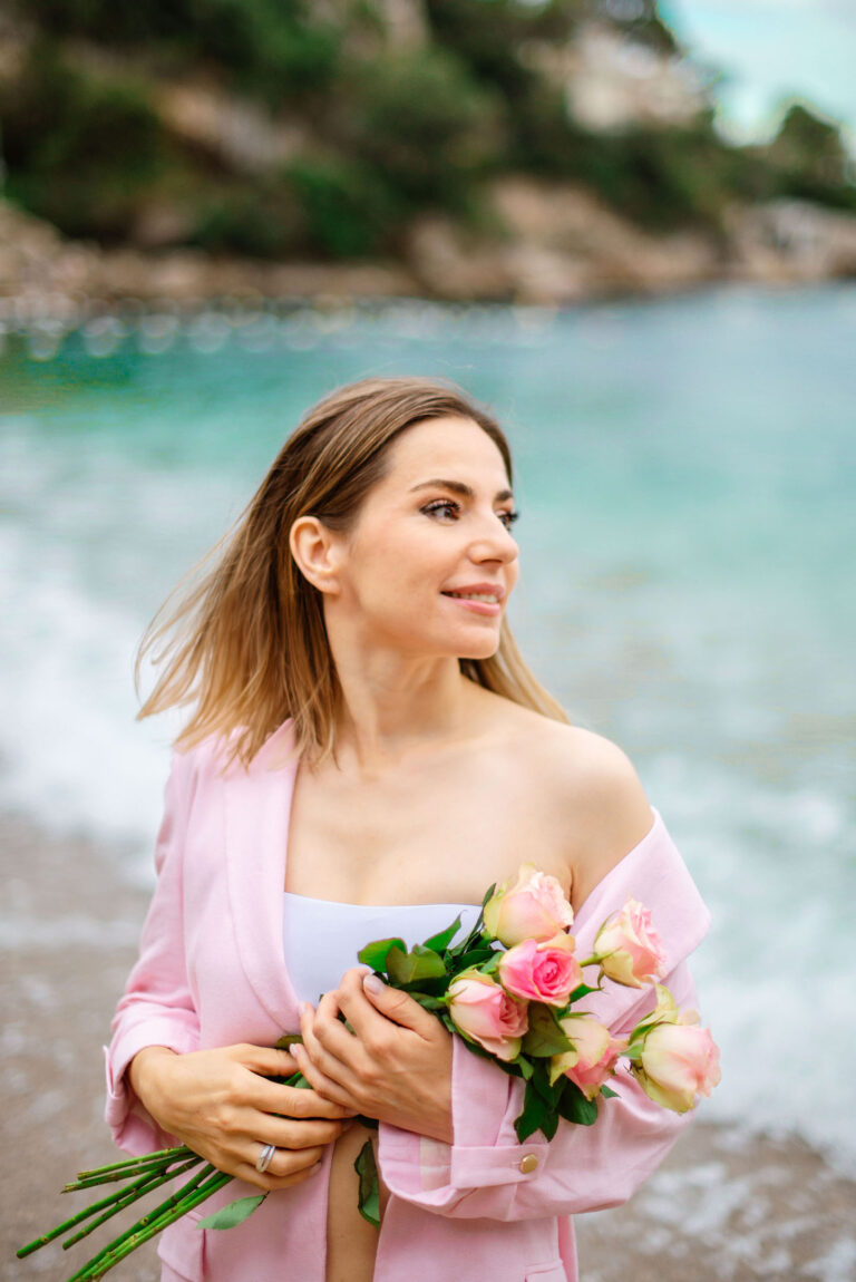 Photographe Côte d’Azur : scène poétique sur le sable avec roses et lumière dorée.