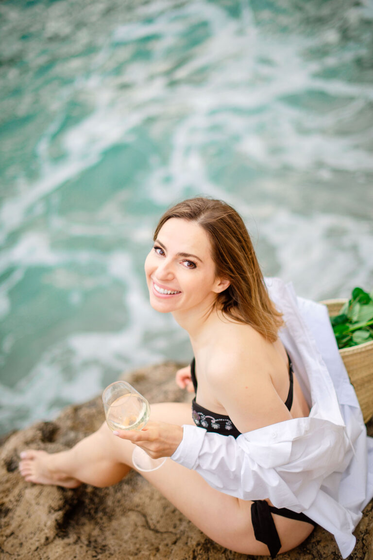 Photographe portrait extérieur : lumière naturelle sur femme en maillot, rocher & mer.