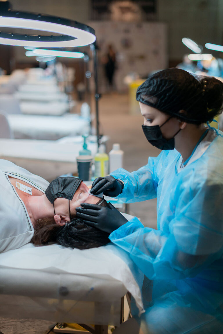 Vue latérale d'un artiste appliquant une technique de microblading sur un modèle.