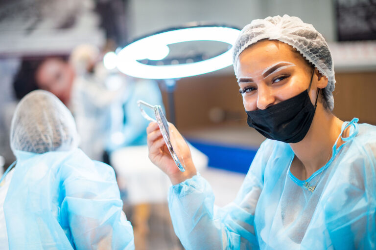 Modèle souriant face à la caméra après l’application du maquillage permanent.