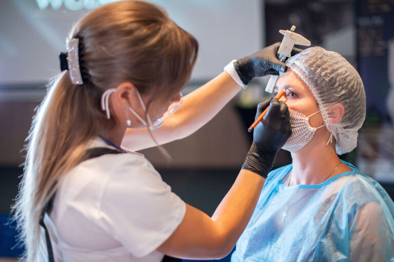 Participant concentré lors de l'application de maquillage permanent sur les sourcils.
