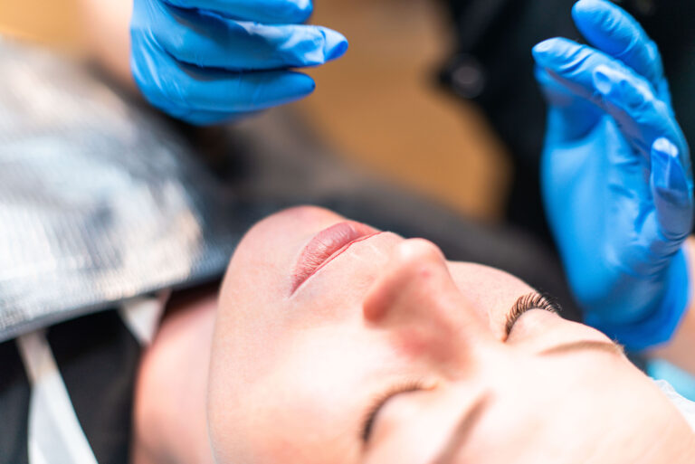 Participant appliquant un maquillage permanent des lèvres avec précision.