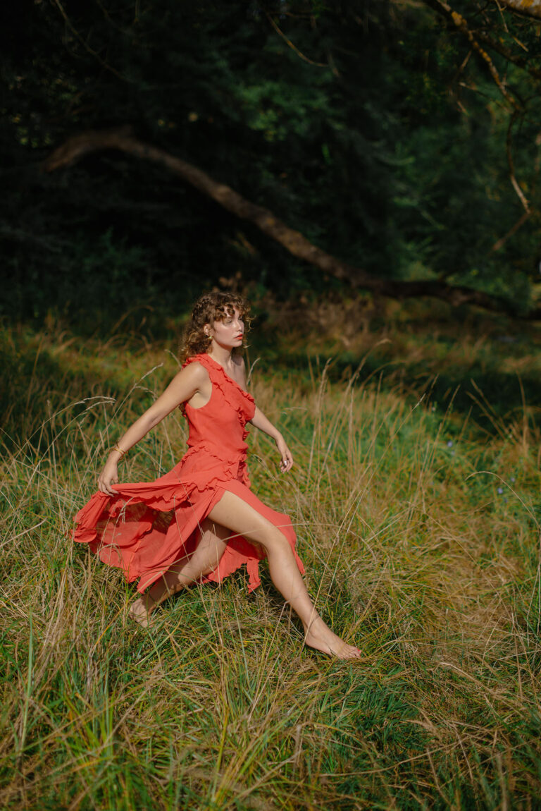 Photographie portrait à Nice, entre douceur et rébellion : une femme, pieds nus dans l’herbe, exprime l’essence de la féminité libre.