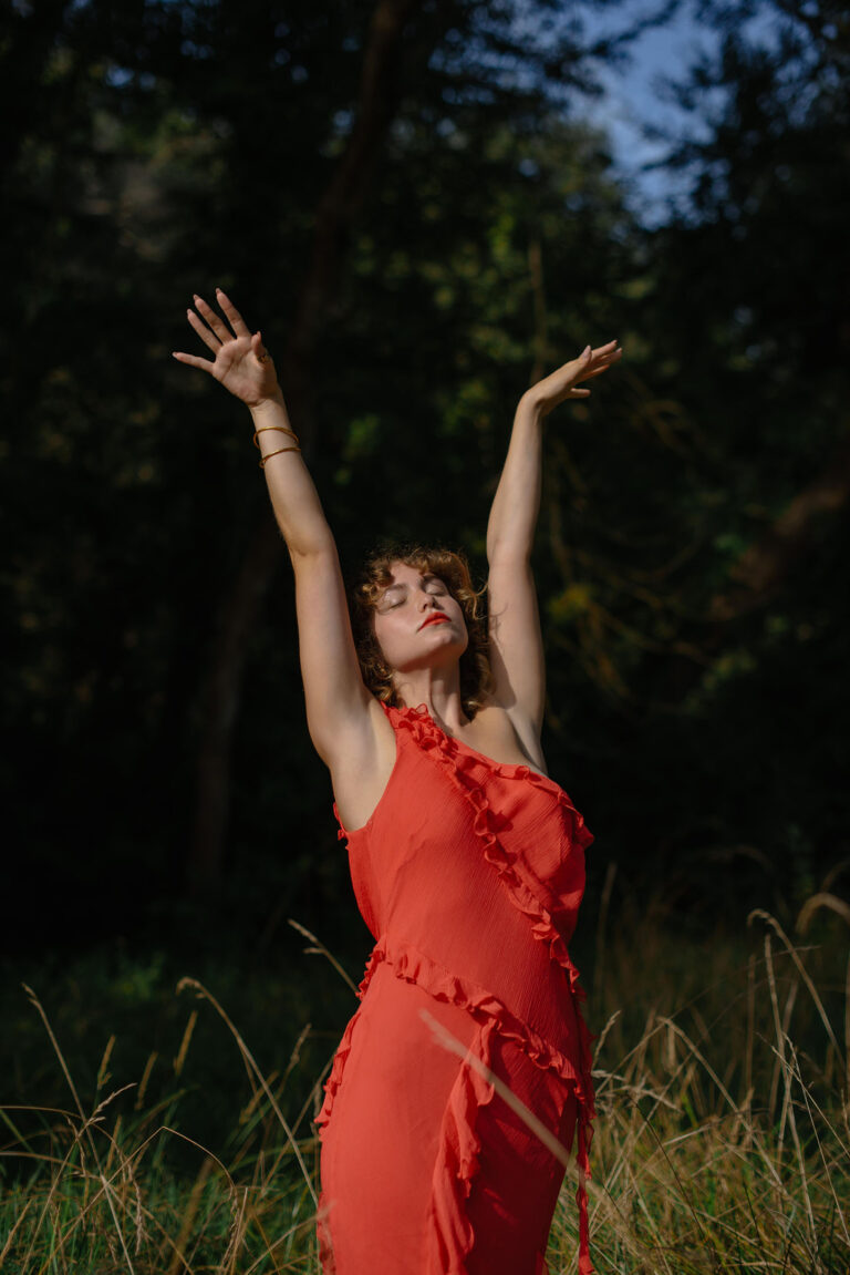 Silvia lève les bras vers le ciel, mouvement libre et spontané – Photographie portrait symbolique Nice.
