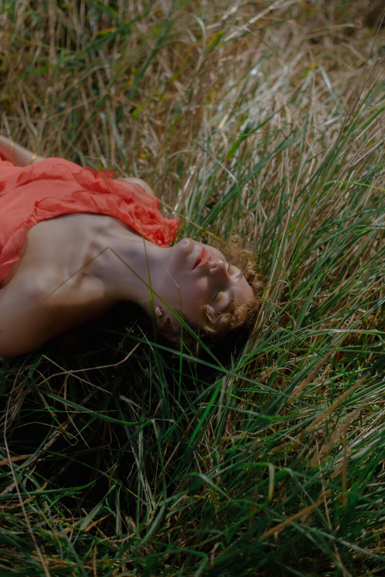 Silvia allongée dans l’herbe luxuriante, regard tourné vers le ciel – Photographie portrait nature Côte d’Azur.