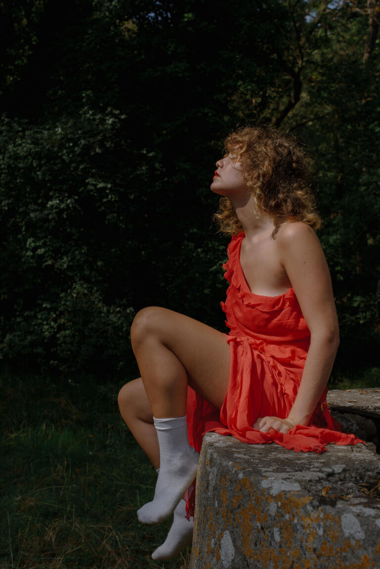Une lumière onirique caresse les mèches dorées de Silvia, ambiance éthérée – Portrait créatif en extérieur.