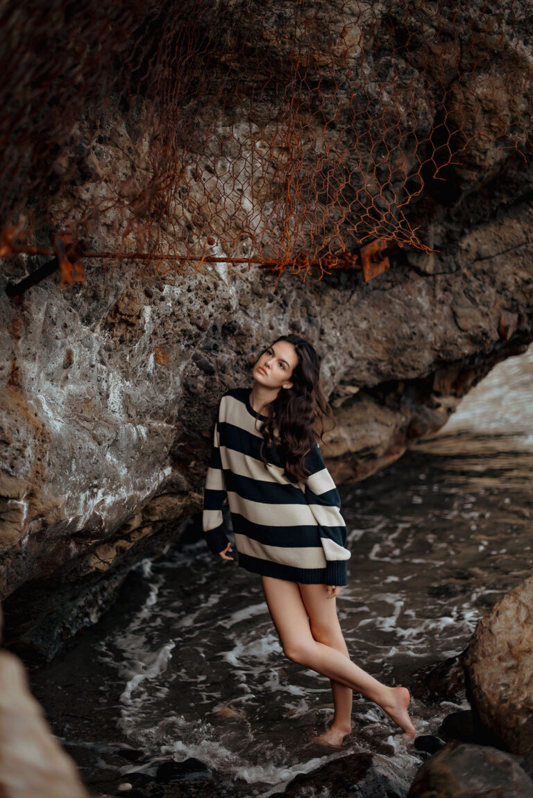 Portrait de modèle en pull rayé noir et blanc sur fond marin – séance artistique Côte d’Azur.