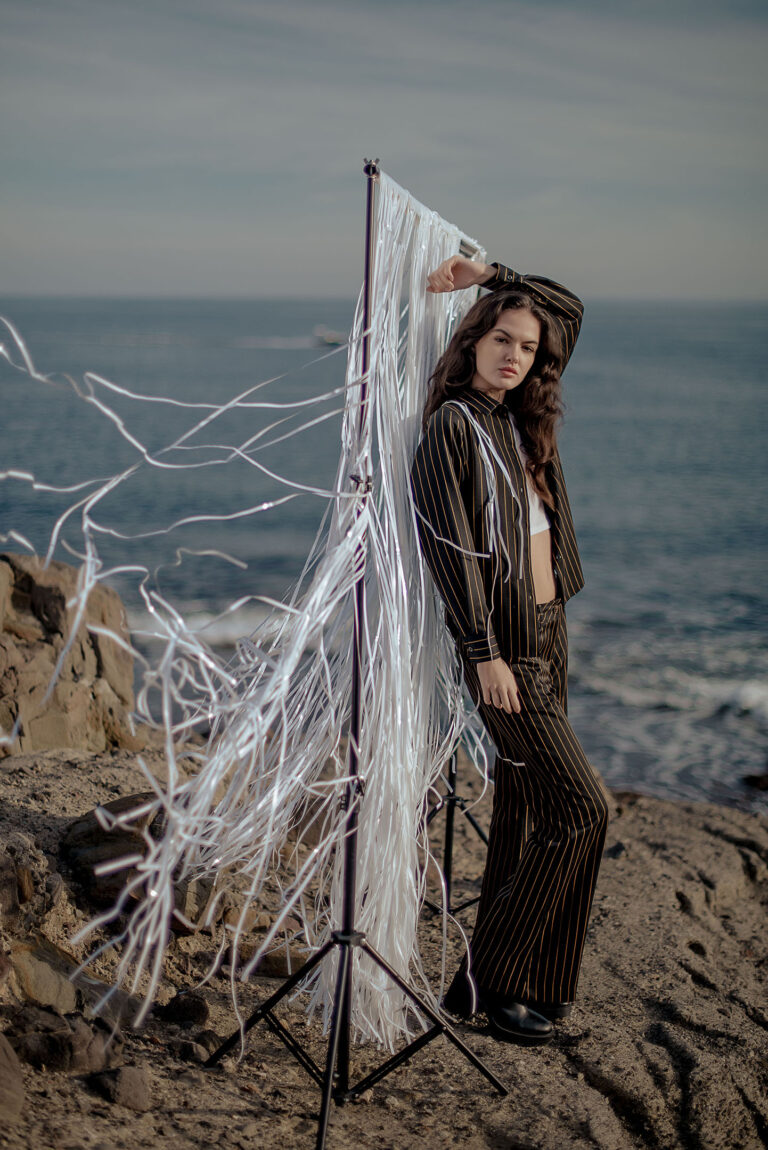 Photographe à Cap d’Ail – modèle en costume foncé posant face au vent.