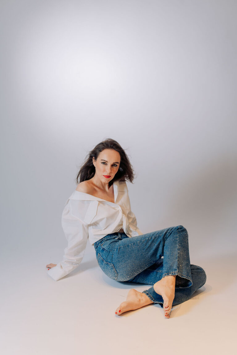 Détail du look : strass du jean captés par une lumière douce en studio.