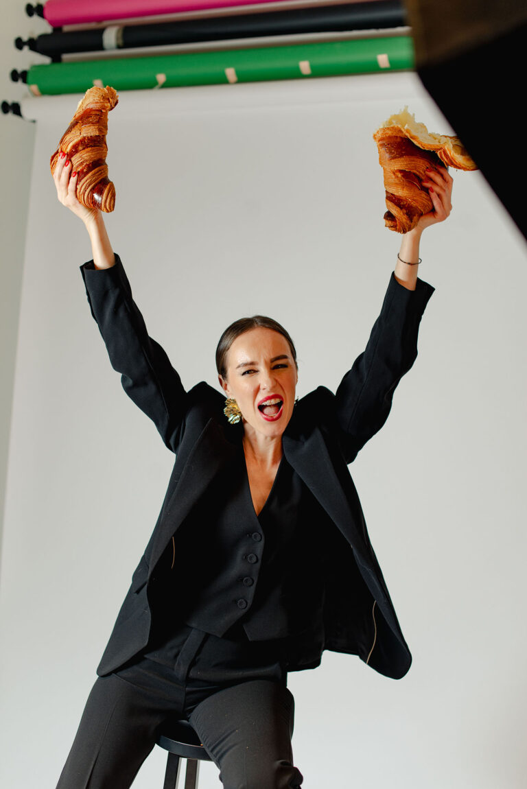 Femme tenant fièrement un croissant géant comme symbole de célébration.