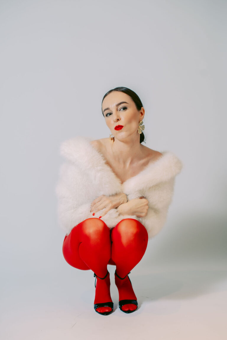Détail glamour : collants rouges et talons hauts, ambiance studio à Nice.