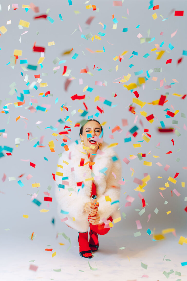 Portrait festif en studio à Nice, une pluie de confettis illumine le visage de la modèle.