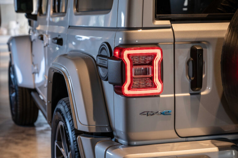 Détail de phare et lignes de carrosserie photographiés en concession automobile