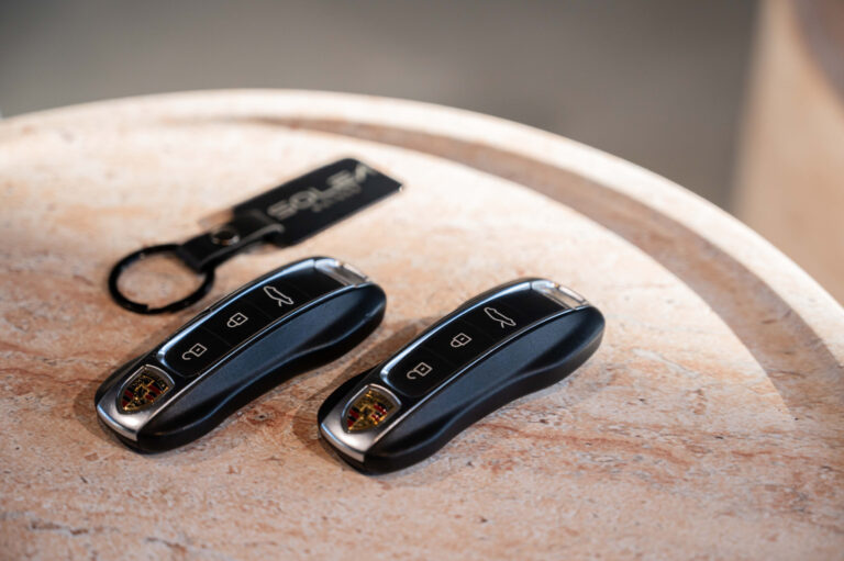Photo des jeux de clés d'une Porsche avec un porte clé de la concession auto